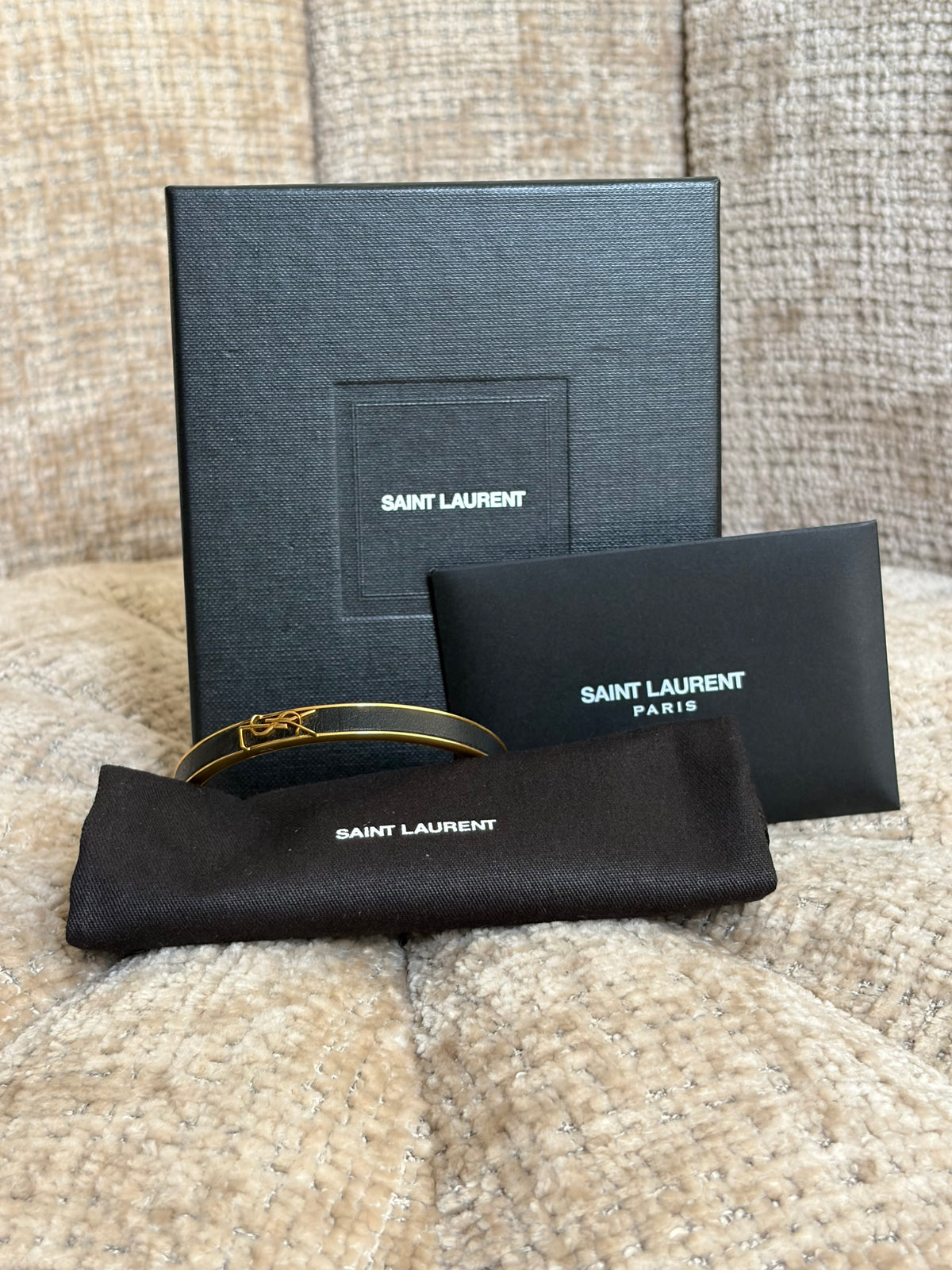 Yves Saint Laurent bangle bracelet in gold-tone brass and black leather, front view